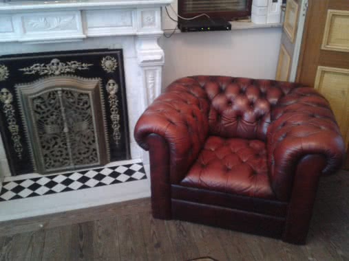 Fauteuil dans une pièce à côté d’une cheminée